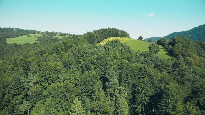 Aerial green nature with hills 4K. Wide drone shot flying above the hills with landscape view.