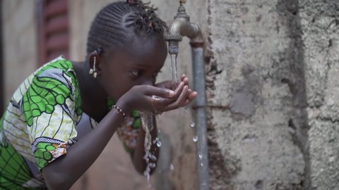 Candid Video of African Schoolgirl drinking Safe water from tap outdoors in Bamako, Mali