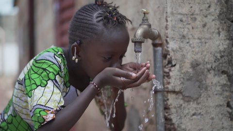 Slow Motion Candid Video of African Girl Women Drinking Fresh Clean Water from Tap in Bamako, Mali