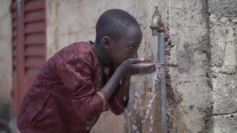 Handsome Little African School Boy Drinks Safe Drinkable Fresh Clean Water from Home Tap