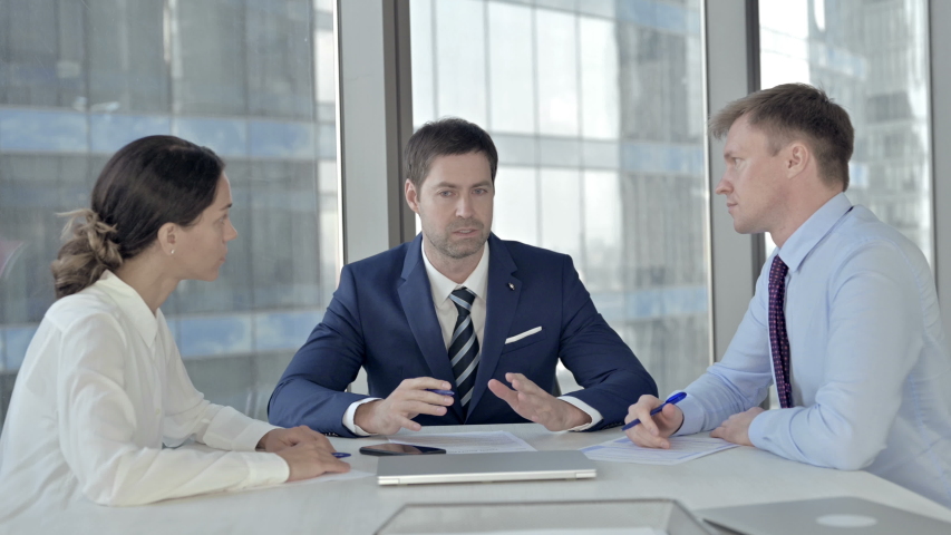 Middle Aged Businessman having Reading Documents with his Assistants in Boardroom | Shutterstock HD Video #1037296388