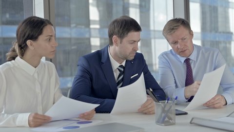 Executive Business people Discussing things through Documents on Office Table
