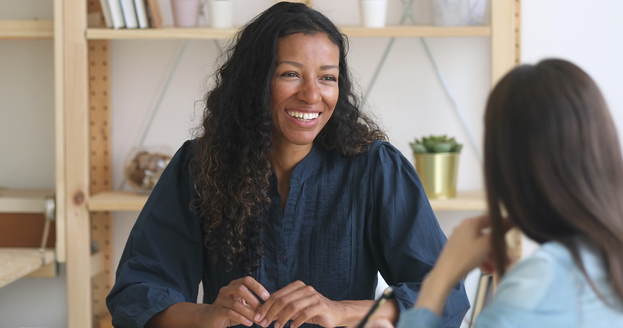 Happy smiling african american businesswoman sales manager or job applicant speaking to hr client colleague customer at business office meeting job interview make good first impression sell services