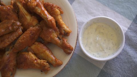 Grabbing One Chicken Buffalo Wing and Dipping in Ranch Dressing