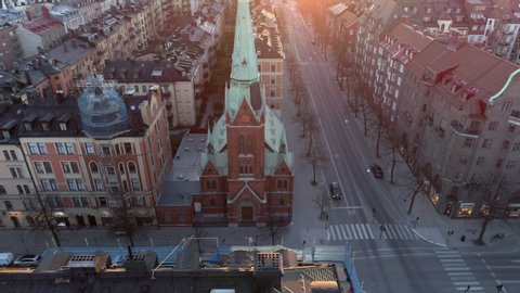Empty street in Stockholm city, Sweden aerial top down view. Quarantined city, empty abandoned streets during corona virus outbreak. Drone shot flying over buildings and street at sunset