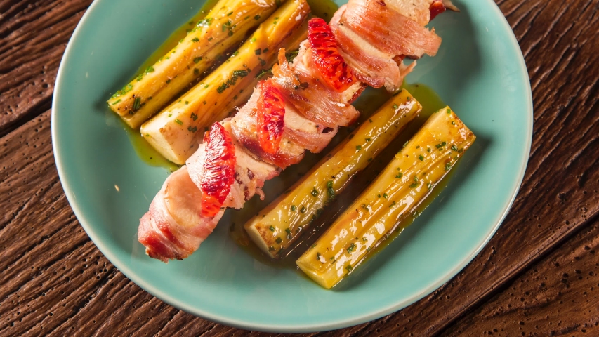 Delicious chicken with bacon and palmito grilled pupunha. Top view with smoke.