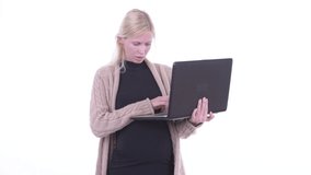 Happy young blonde pregnant woman video calling with laptop
