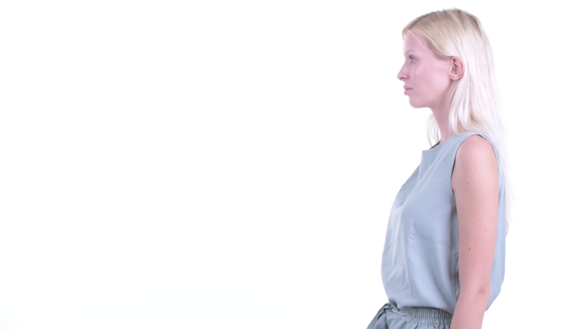 Profile view of happy young beautiful blonde woman smiling with arms crossed