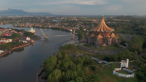 Cinematic aerial shot along the Sarawak River at Kuching Waterfront, noise are existed in a drone footage video