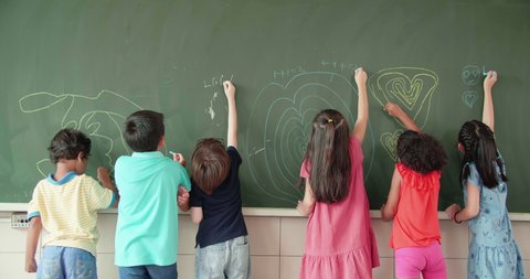 Multi-ethnic group of school children drawing on the chalkboard
