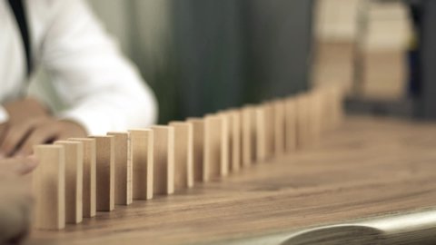 Wooden blocks falling in line domino effect