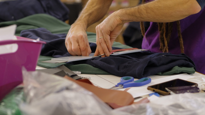 manual work, creativity, sewing. Sewers hands cutting fabrics in his laboratory