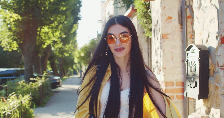Gorgeous smiling caucasian woman flirting attracting hands on camera close-up while walking in the street.