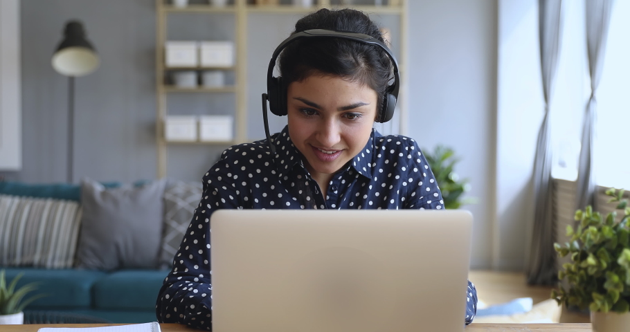Smiling indian young business woman wear wireless headset video conference calling on laptop computer talk by webcam in online chat, customer support service and distance online teaching concept Royalty-Free Stock Footage #1037339309