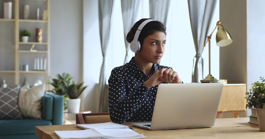 Focused indian woman distance teacher online tutor wear headphone conferencing on laptop communicate with student by webcam video call chat explain course help e learning computer education concept Royalty-Free Stock Footage #1037339321
