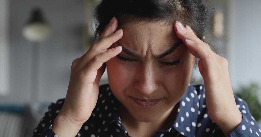 Frustrated stressed upset young indian woman coping with headache migraine concept feel anxiety pain pressure, mental stress, panic attack touching aching sore head at home office, face close up view Royalty-Free Stock Footage #1037343017