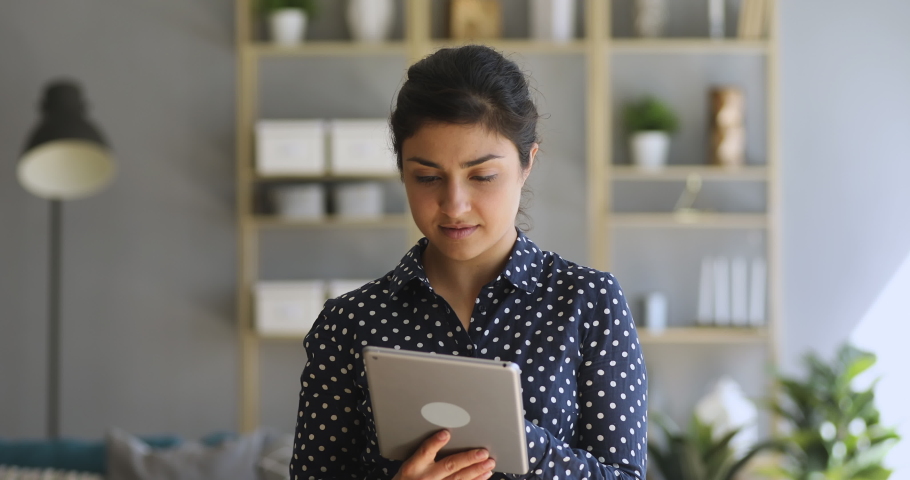 Focused indian woman holding using digital tablet online apps at home office, young ethnic girl student surfing web working studying in internet spending time with modern device technology indoors Royalty-Free Stock Footage #1037344565