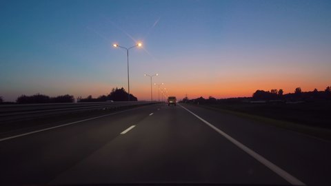 Driving Car POV On Freeway In Of Night In With Little Traffic After Sunset. Evening Sunset Street Lights. Night, Camera In Front, Windshield Reference. Driving Car On Highway At Dark 4K POV.
