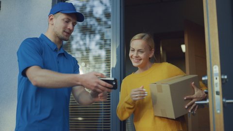 Beautiful Young Woman Opens Doors of Her House and Meets Delivery Man who Gives Her Cardboard Box Postal Package, She Signs Electronic Signature POD Device. Slow Motion