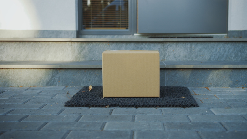 Contactless Delivery of Internet Ordered Goods, Cardboard Box Package on the Door Step, Anonymous Woman Walks out of the Front Door and Picks-up Her Postal Parcel. Safe No Contact Delivery | Shutterstock HD Video #1037351165