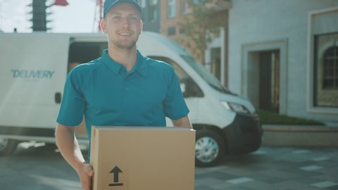 Handsome Courier Takes Cardboard Box Package out of Delivery Van Walks Through Modern Stylish Business District. Courier On the Way to Deliver Postal Parcel to a Client. Shot on RED EPIC-W 8K