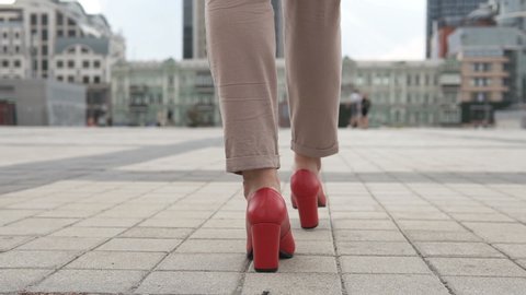 Business female legs in red high-heeled shoes