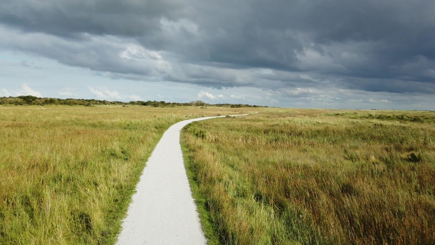 Bicycle path through Marshland POV driving on road in Schiermonnikoog, the Netherlands