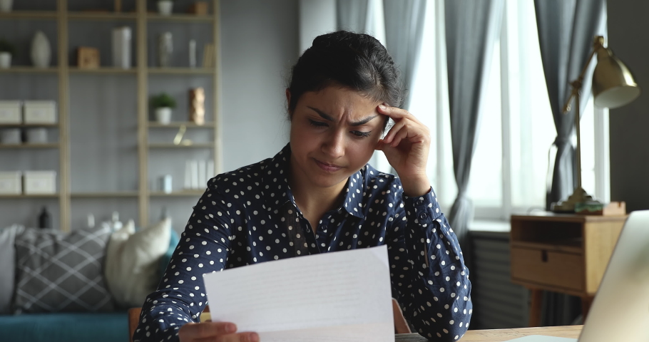 Upset stressed indian ethnic girl feel frustrated open envelope at home reading bad news receive paper post mail letter about financial problem, bank debt bill, failed exam test results or subpoena | Shutterstock HD Video #1037354036