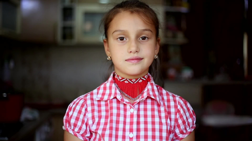 Portrait of smiling child girl dressed in red.