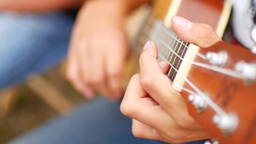 Child plays the guitar, ukulele. Close-up