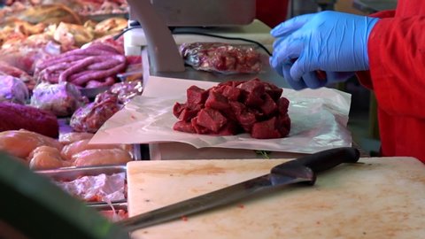 Shoulder Of Beef Being Sliced And Diced and wrapped in the paper for customer in the market of Paris, France.