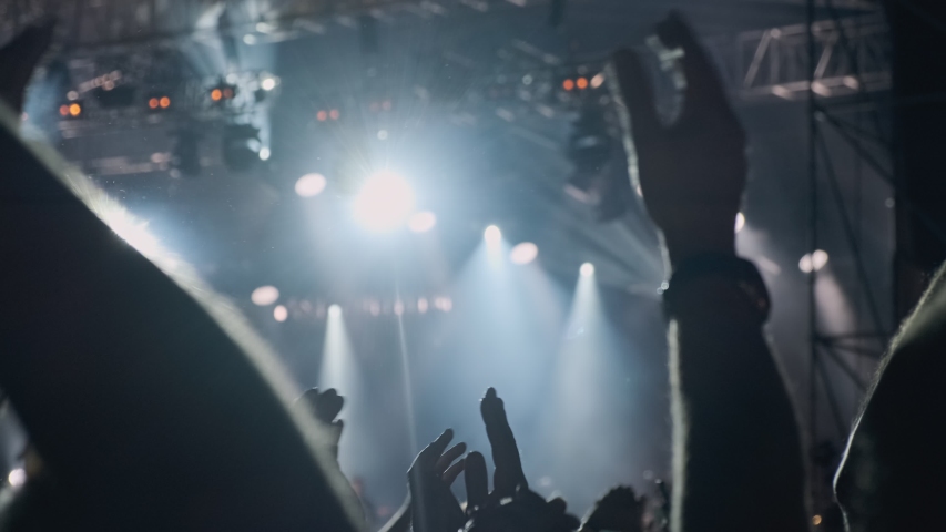 Silhouette hands of audience crowd people use smart phones enjoying the concert. Big crowd at concert cheering clapping hands at night rock concert. 4k, UHD | Shutterstock HD Video #1037366975