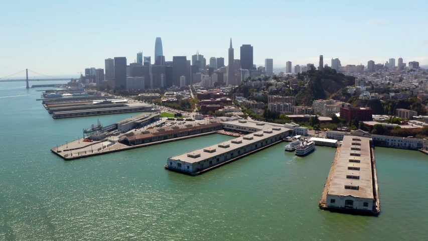 Flying over San Francisco in California. Aerial view of the city by the bay near the docks. 