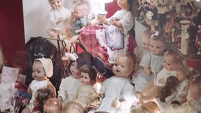 Antique ceramic dolls of different periods. Showcase of ceramic dolls in vintage store.4k - Powered by Shutterstock - Get 15% off with code: PIKWIZARD15