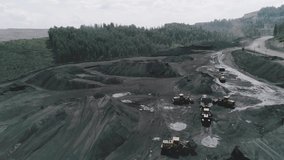loading coal on a quarry overlooking the forest aerial video