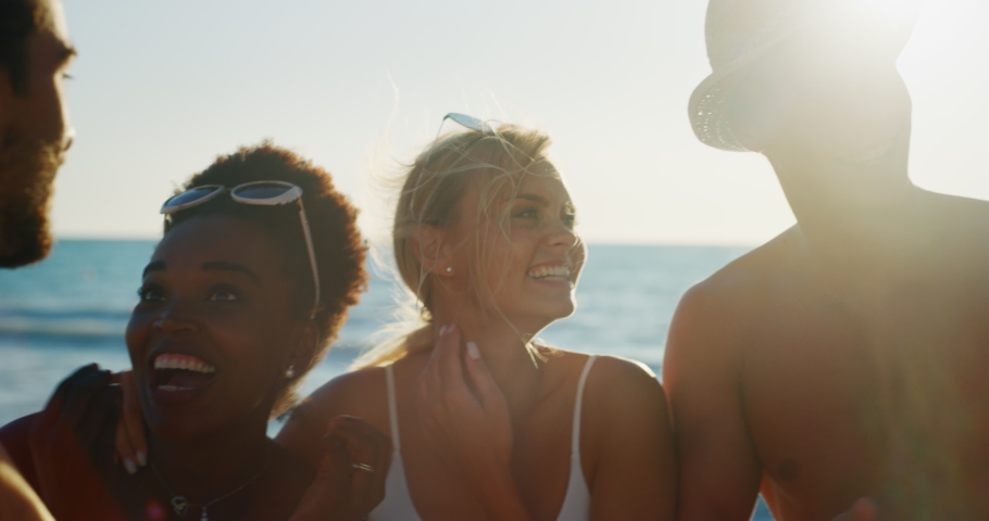 Slow motion of young multi-ethnic friends in swimsuits  are having fun to enjoy their summer vacation together on a beach with a sea in a sunny day.