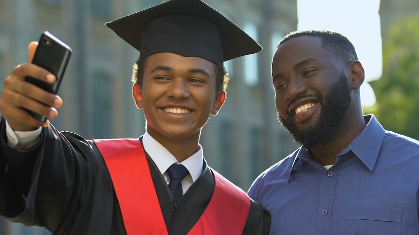 Happy emotional teenager in magisterial gown and father making selfie graduation Royalty-Free Stock Footage #1037410532