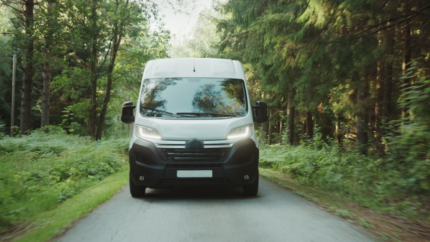 New Delivery Van / Truck Driving Through the Green Woods. Postal Delivery Service. Front View Following Shot Royalty-Free Stock Footage #1037416160