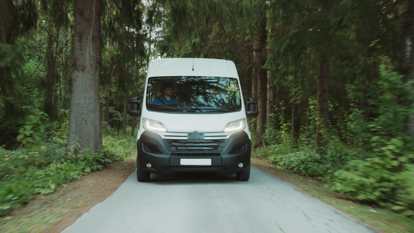 New Delivery Van / Truck Driving Through the Green Woods. Postal Delivery Service. Front View Following Shot Royalty-Free Stock Footage #1037416160