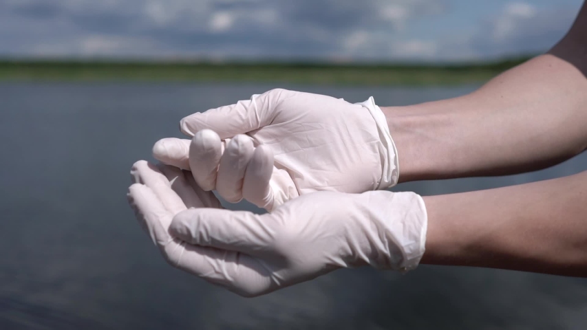 Liquid mud flows into the hands of man. This video is about fertilizer or dirt. She pours into the hands of man. Demonstration of texture.