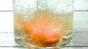 Dissolving effervescent tablets in slow motion against a white wooden backdrop in an old glass jar - Powered by Shutterstock - Get 15% off with code: PIKWIZARD15