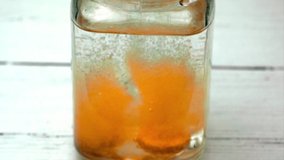 Dissolving vitamin tablets in slow motion with bubbles against a white wooden backdrop in an old glass jar - Powered by Shutterstock - Get 15% off with code: PIKWIZARD15