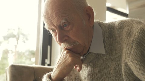 Pensive elder senior man looking away feel upset, thoughtful melancholic older retired gray haired grandpa suffer from sorrow grief loneliness, sad grandfather widower alone at home, close up view