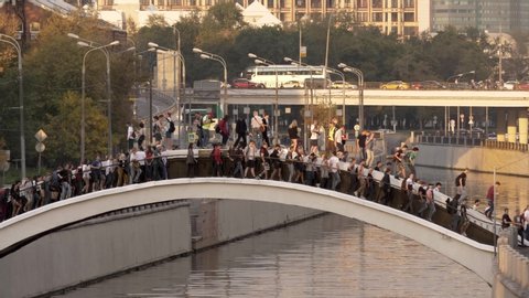 Protesters on the bridge. The activist climbed the bridge and holds the flag of Russia. Protest marches in the city center. Student protest. People cross the river.
Moscow,Russia,AUGUST,31,2019.
