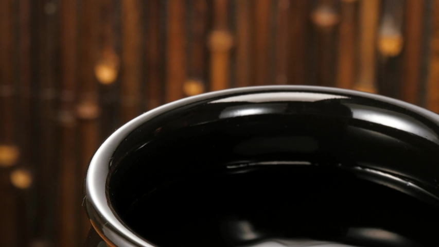 Scoop up shochu with ladle in earthenware jar