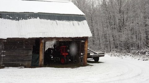 Rustic Wood Barn with a Red Antique Super H Tractor in a Blizzard, Establishing Shot