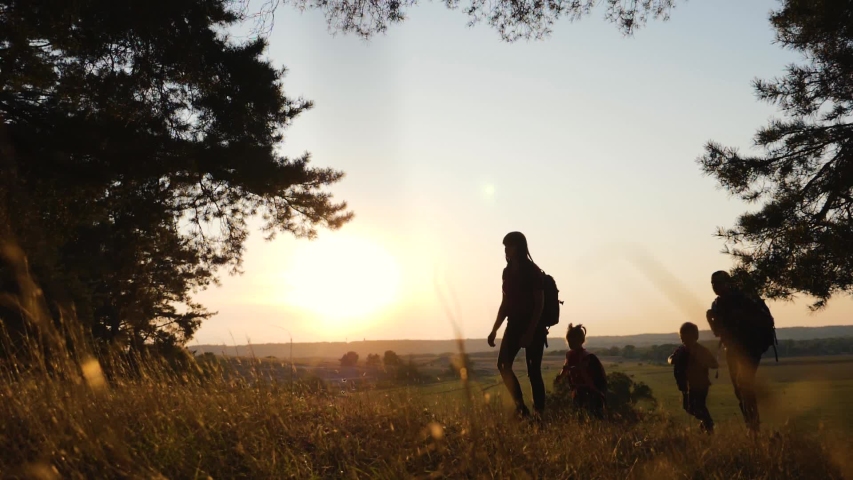 A happy family. Family travel and hiking through the forests at sunset. Walking in the open air, teamwork. Healthy lifestyle concept | Shutterstock HD Video #1037468387