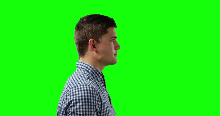 Side view close up of a young Caucasian man wearing a checked shirt, greenscreen