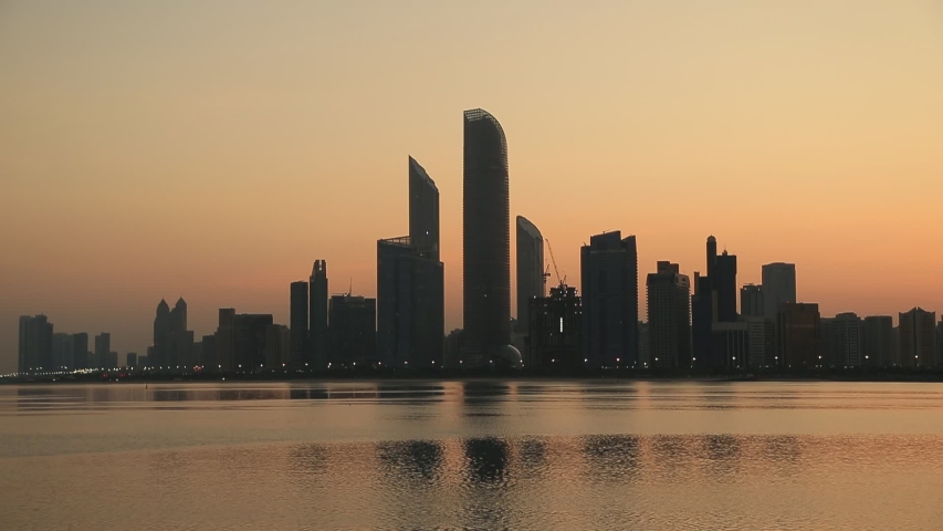 Sunrise in Abu Dhabi, United Arab Emirates. Birds flying across the frame.