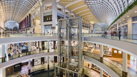 Singapore, Singapore city, 06-15-2019, TL/ time lapse of people inside the Marina Bay Sands Shoppers shopping mall, showing the modern interior design, with people using lifts and escalators